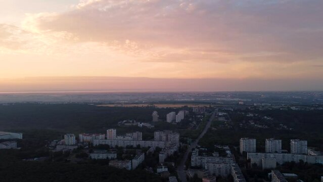 Aerial left to right view of Kharkiv city center streets in sunrise. Park of Maxim Gorky and residential multistory buildings with scenic morning cloudy sky