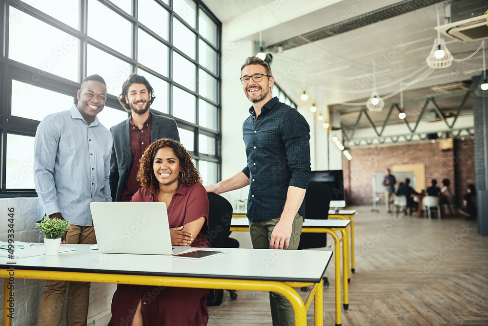 Wall mural Were the only team you need. Cropped portrait of a group of businesspeople standing around a desk in their office.