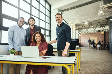 Were the only team you need. Cropped portrait of a group of businesspeople standing around a desk...