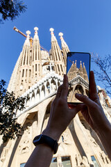 Fototapeta premium Taking a photo of Sagrada Familia with a mobile phone camera in Barcelona, Spain.