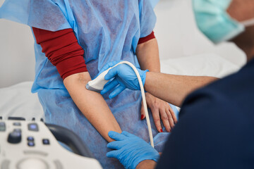 Doctor performs an ultrasound using a device of a female patient