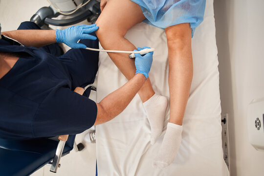 Orthopedist Doctor Doing Ultrasound Examination Of Patient's Leg Veins In His Office