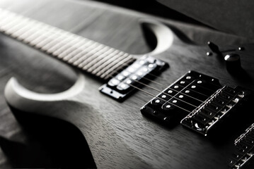 Fototapeta na wymiar Ebony electric guitar on a dark surface
