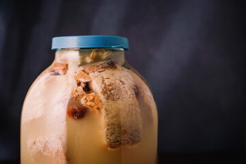 Jar of homemade bread kvass on wooden background. Traditional slavic beverage kvas, cold summer drink. Copy space, closeup shot