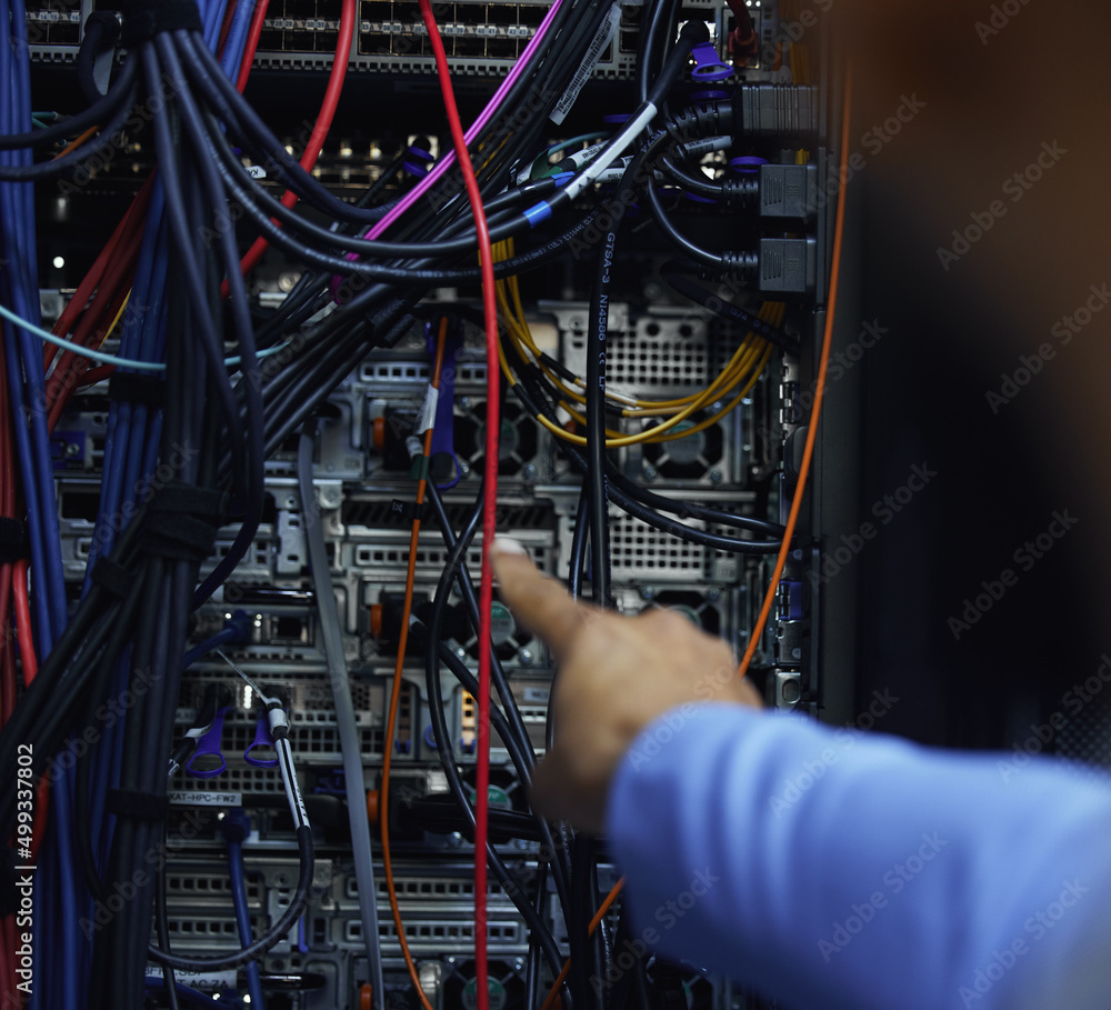 Poster Sometimes its just a matter of connecting point A to point B. Cropped shot of an unrecognizable male IT support agent working in a dark network server room.