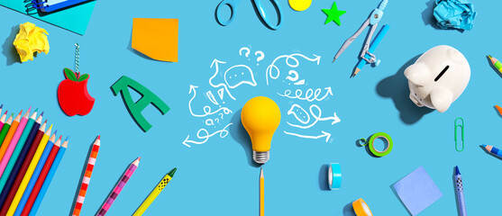 Brainstorming concept with a light bulb and school supplies - Flat lay