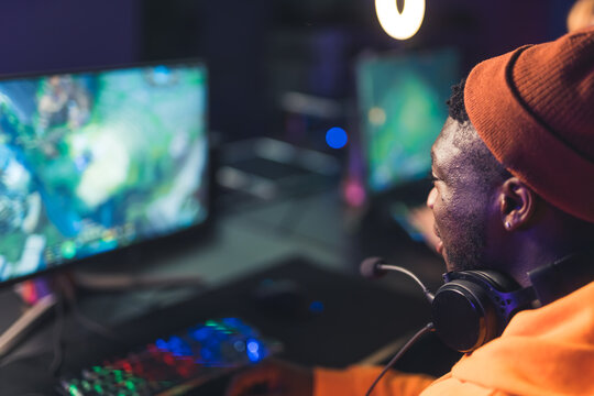 Afro American young man playing online video games game battles esport concept closeup neon light indoors. High quality photo