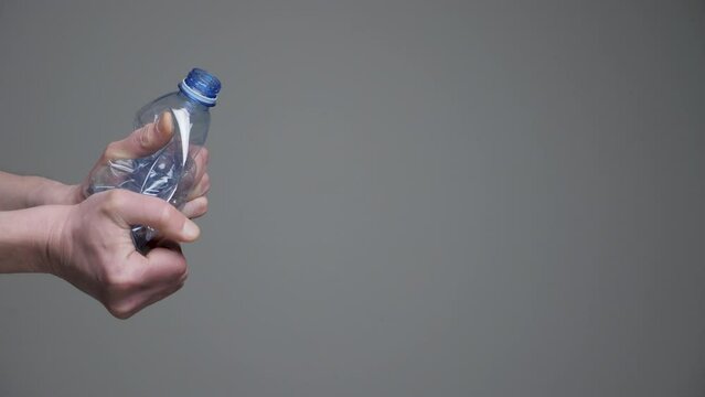 Hands twisting bottle crumpled plastic reduce concept. Crushed bottle water. Resize. Used pet. Grab hands crushed plastic bottle recycle pet plastic reduce waste materials recyclable waste management