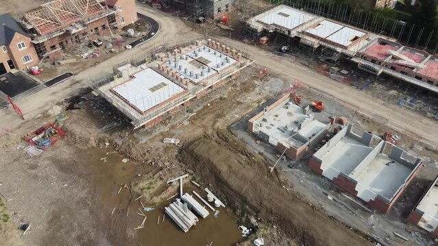 ew UK housing development, showing houses under construction and new builds, in the UK. 4K Arial footage, high quality videography. UK housing project, all stages of construction and development.