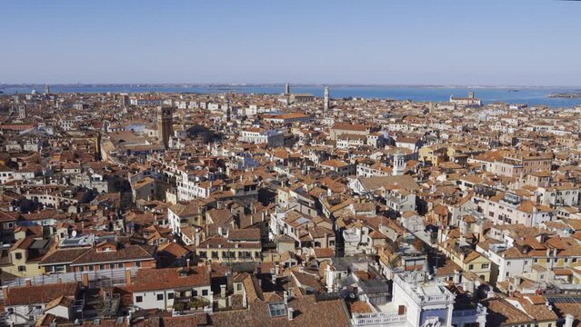 Venice Italy elevated day view panorama from St Marks Campanile with traditional low-rise red tile roof buildings visible and Torre dell Orologio Renaissance tower.