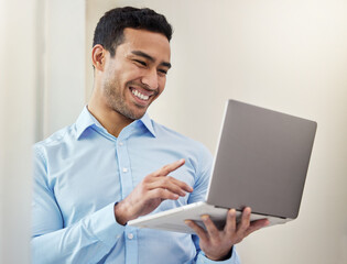 So many emails to be sent. Shot of a young businessman using his laptop in his office.