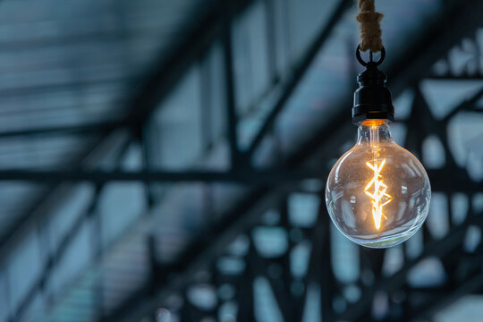 Retro Tungsten Edison ceiling lamps light bulbs decorated on steel roof structure background interior office building or home and living.
