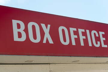 red and white sign that reads: box office