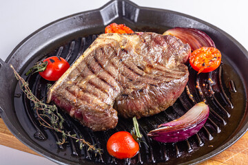 Grilled premium rib eye beef steak in the pan, cooking steak in the kitchen on a dark background, top view