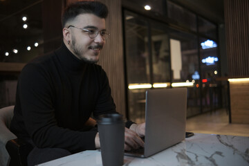 man working with laptop in cafe