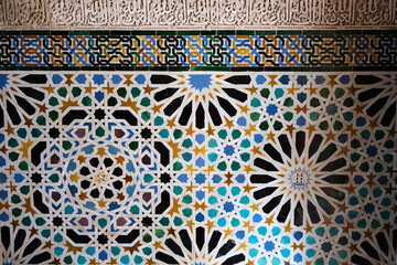 Alhambra, Detailed background of the Alhambra Palace with intricate tile patterns on the wall and arabic writing in the middle. Ceramic wall - obrazy, fototapety, plakaty