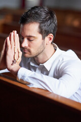 He knows where his strength comes from. Shot of a young man praying in a church.