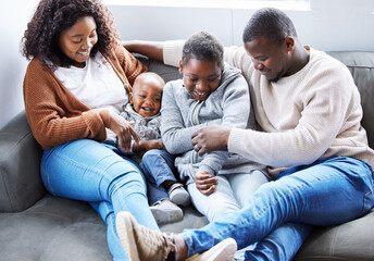 Home is where the heart is. Shot of a family playing together on the couch in the lounge at home.