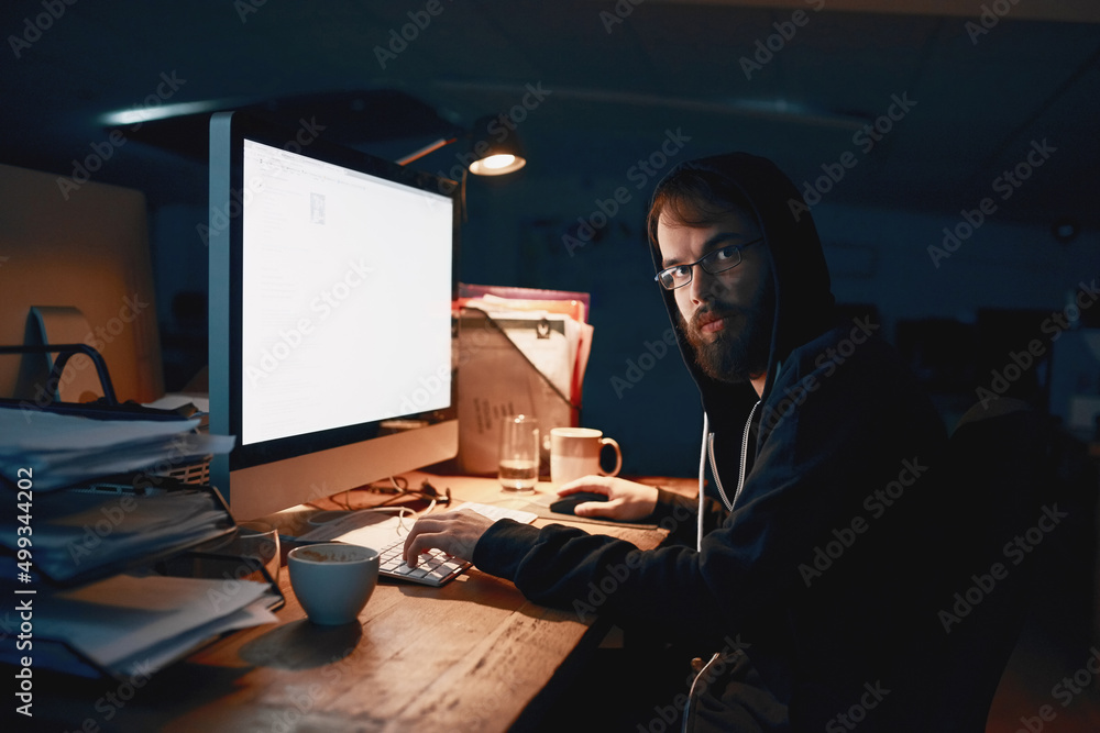 Poster Late nights are normal for a programmer. Cropped portrait of a young computer programmer working late in the office.