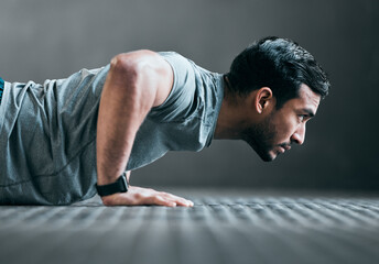 Forward focus. Cropped shot of a handsome young male athlete doing pushups against a grey background. - obrazy, fototapety, plakaty
