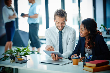 Advancing their way through business with technology. Cropped shot of colleagues working together...