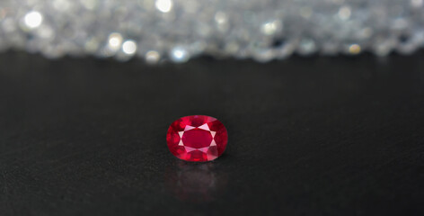 A beautiful red gem or ruby is placed on the ground.