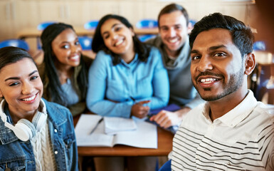 College is awesome. Cropped portrait of a group of young university students sitting in class.
