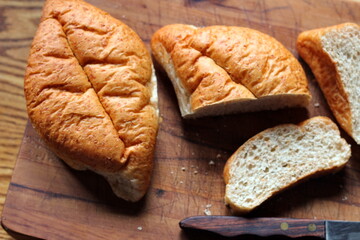 Bread on a wooden cutting board It's a freshly made bread. Photo Flat-lat