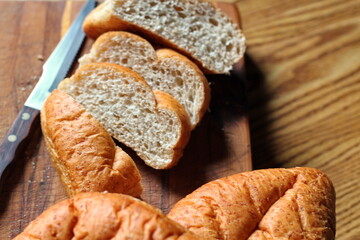 wheat bolillos placed on a wooden table. Flat-lay photo.