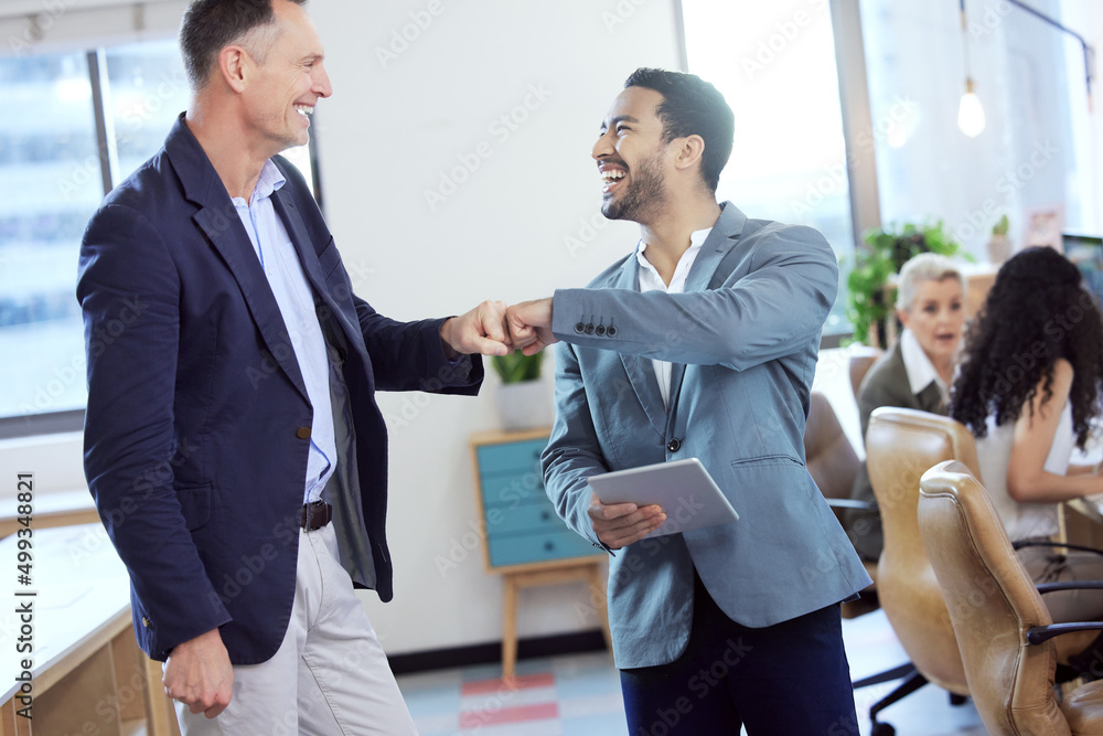 Canvas Prints I support you. Shot of two young businesspeople giving each other a fist bump in an office at work.