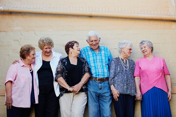 The older we get, the more we enjoy life. Shot of a group of seniors standing against a wall outside.