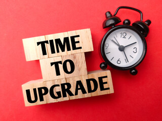 Alarm clock with word TIME TO UPGRADE on red background.