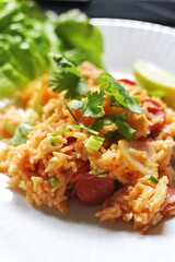 Vertical picture, pork and sausage fried rice served in a plate with lettuce and coriander garnish. Fried rice is a street food that is sold in Thailand.