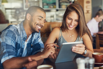 We should definitely check this event out over the weekend. Cropped shot of a young couple using a digital tablet while sitting in a cafe. - obrazy, fototapety, plakaty