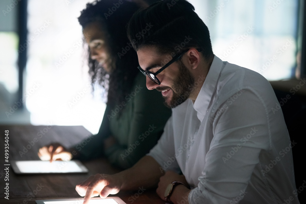 Poster focused on getting the job done no matter what. cropped shot of two colleagues working late on their