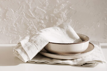 Modern ceramic tableware on table with copy space.  Trendy plates, cutlery and linen napkins...