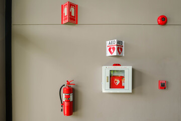 Fire alarm system on a brick an emergency during fire.Automated External Defibrillator AED emergency life saving equipment mounted on wall of rowing club. - obrazy, fototapety, plakaty