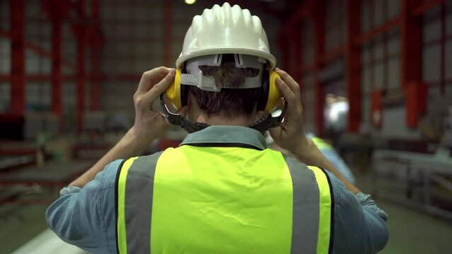 Industrial engineer wearing a sound protection headphones before working.