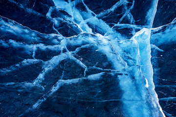Texture blue transparent ice with cracks frozen Lake Baikal in winter, top view