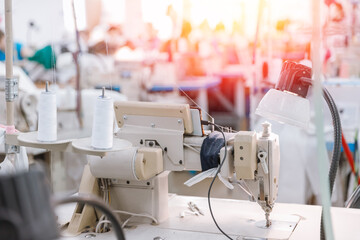 Concept Interior of garment factory. Closeup spool of multicolored threads for sewing machine