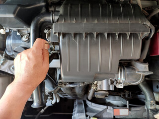 Man checking engine air filter system.