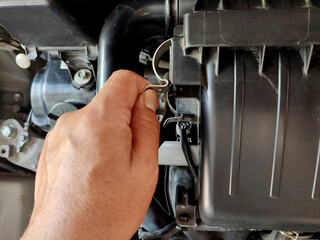 Man checking engine air filter system.