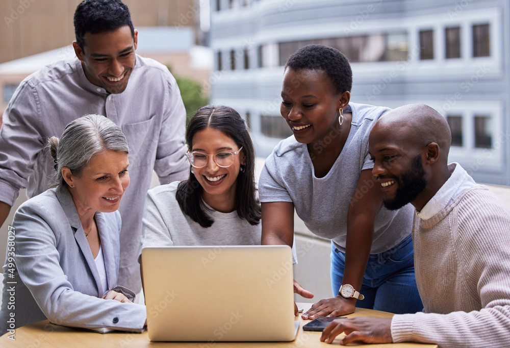 Poster have a burning desire to succeed. shot of a group of professional coworkers using a laptop together 