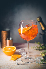 Aperol spritz cocktail in glass with fresh orange on gray background