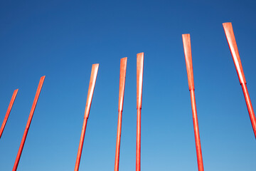 Several red oars against a blue sky on a sunny day