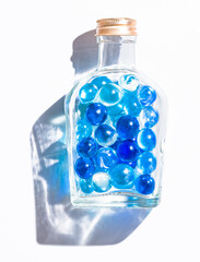 Fresh blue marble balls in a glass bottle, Cool summer background