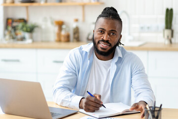 Distance learning, online education. Portrait of smiling African American adult male freelancer...
