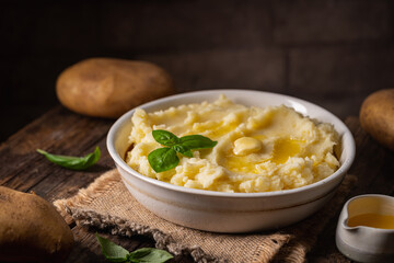 Mashed potatoes in white bowl on wooden rustic table. Healthy food