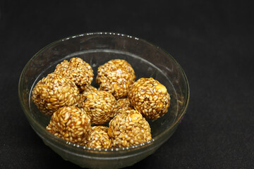 The sweet sesame balls are in a cup. On a black background