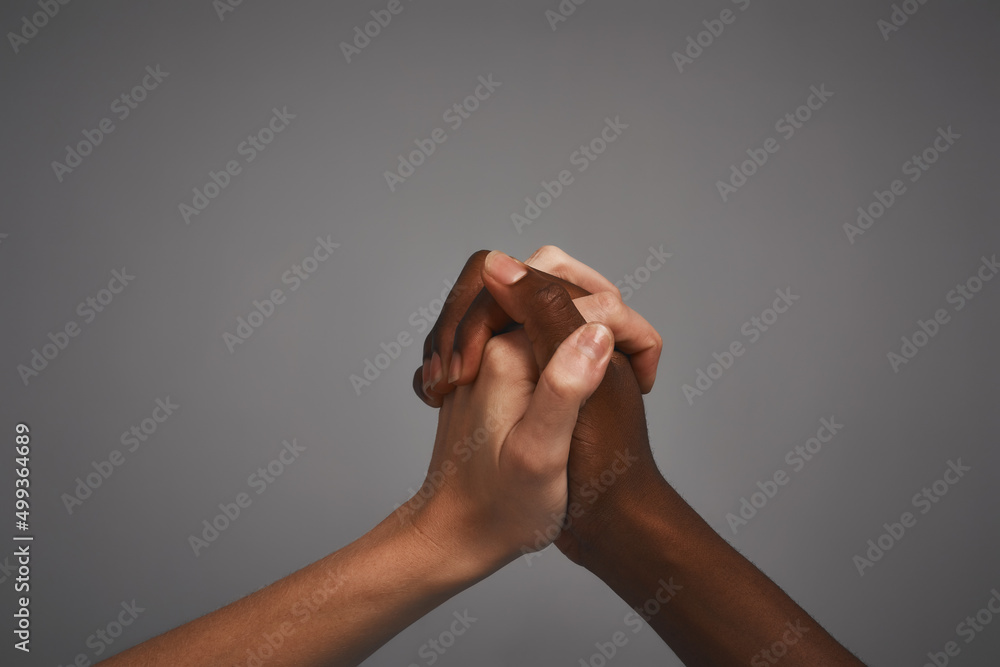 Poster inside, were the same. studio shot of unidentifiable hands holding on to each other against a gray b